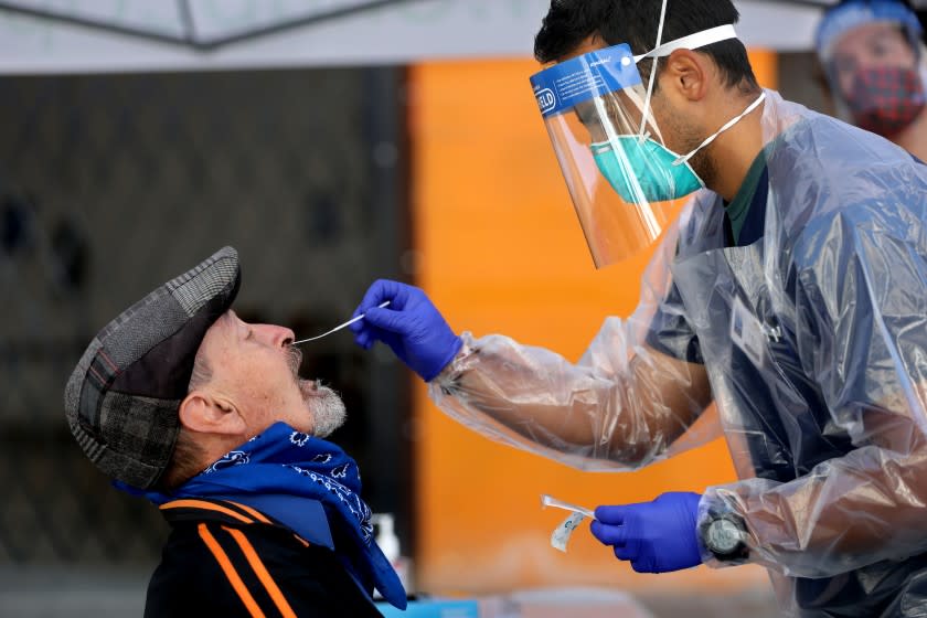 SAN FRANCISCO, CA - JULY 09: Ernesto Contantini, 72, left, of San Francisco, receives a Covid-19 test by Luis Viafranco, a nursing student at San Francisco State University, at a testing site administered by the Latino Task Force and the San Francisco Department of Public Health, at the Mission Language and Vocational School in the Mission District on Thursday, July 9, 2020 in San Francisco, CA. Constanini said this was his second test taken and he was doing it for precaution. University California San Francisco new study shows economic factors fueled COVID-19 transmission in Latino essential workers and families despite shelter-in-place in the Mission District. (Gary Coronado / Los Angeles Times)