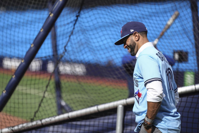 Former Toronto Blue Jays player Jose Bautista, left, signs a fan's jersey  before the Jays take on the Chicago Cubs in Toronto, Friday, Aug. 11 2023.  The Jays will honor Bautista's legacy