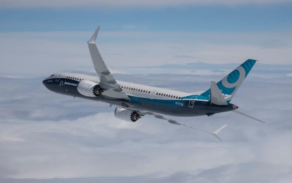 A Boeing 737 MAX 9 flying over clouds