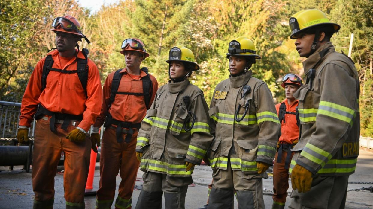  From left to right: two 3 Rock fire fighters, Gabrielle, Eve and Jake standing on a bridge. 