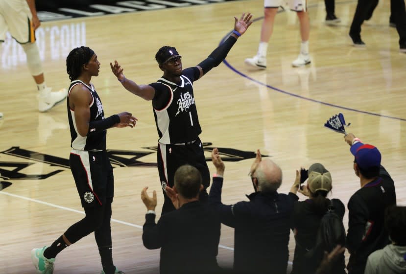 The Clippers' Reggie Jackson, right, and Terance Mann celebrate with the crowd during a Game 6 win June 18, 2021.