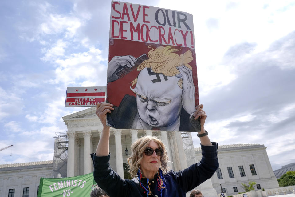 A demonstrator stands outside the Supreme Court as the justices prepare to hear arguments over whether Donald Trump is immune from prosecution in a case charging him with plotting to overturn the results of the 2020 presidential election, on Capitol Hill Thursday, April 25, 2024, in Washington. (AP Photo/Mariam Zuhaib)