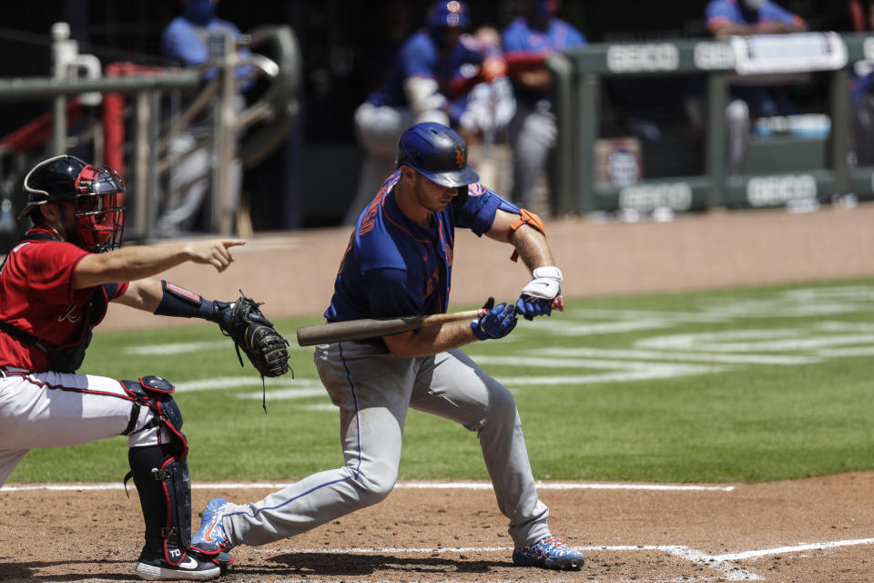 New York Mets' Pete Alonso, right, strikes out in the fifth inning of a baseball game on Sunday, Aug. 2, 2020, in Atlanta. (AP Photo/Brynn Anderson)