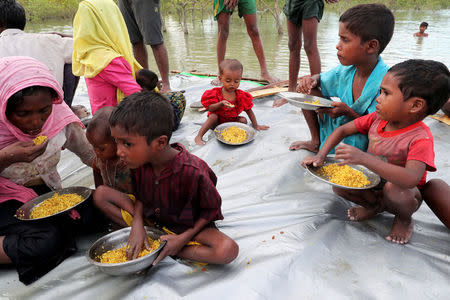 Rohingya refugee eat a meal while crossing the Naf River with an improvised raft to reach to Bangladesh in Teknaf, Bangladesh, November 12, 2017. REUTERS/Mohammad Ponir Hossain TEMPLATE OUT