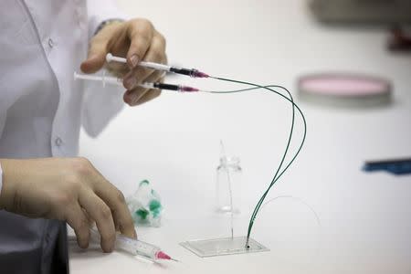 A SpacePharma employee works on a miniature laboratory that will carry out experiments in space, in their offices in Herzliya near Tel Aviv February 24, 2015. REUTERS/Amir Cohen