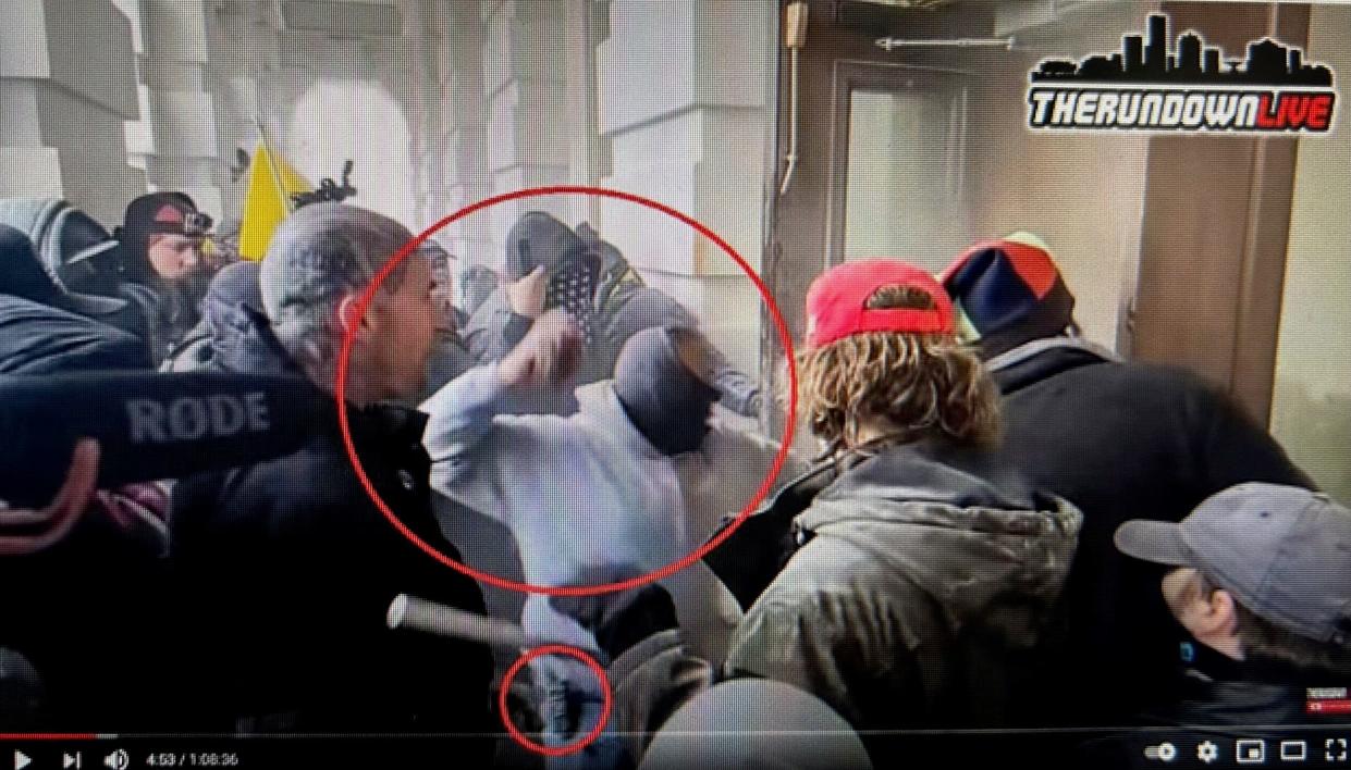 Anthony Sargent repeatedly threw an unknown object at the inner doors of the north entrance of the Capitol and and along with other rioters caused more than $1,000 in damage. The smaller red circle indicates what appears to be a radio.