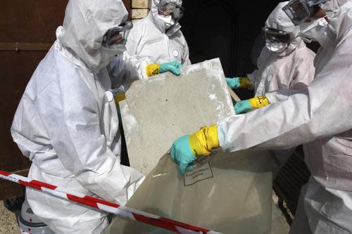 men in hazmat suits clearing old asbestos insulation