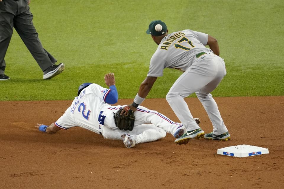 Texas Rangers' Marcus Semien (2) steals second as Oakland Athletics shortstop Elvis Andrus (17) is unable to secure the throw to the bag in the first inning of a baseball game, Wednesday, July 13, 2022, in Arlington, Texas. (AP Photo/Tony Gutierrez)