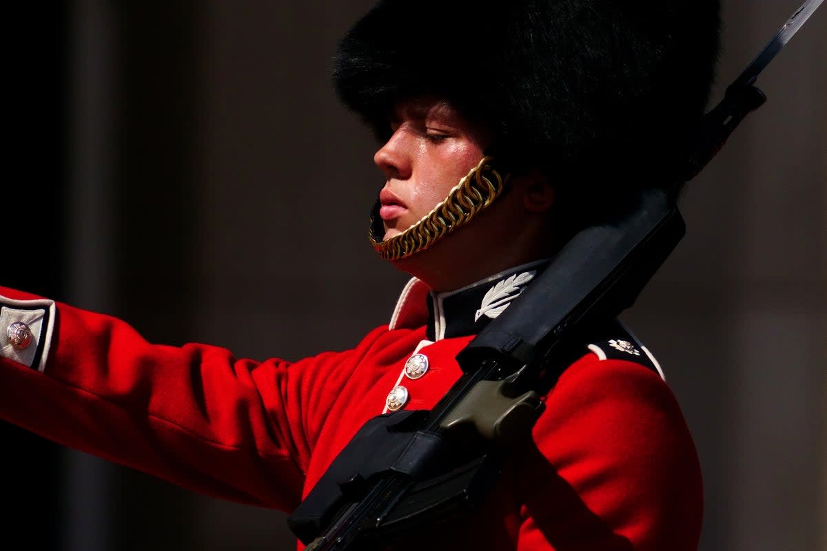 A member of F Company Scots Guards swelters in the heat during the Changing of the Guard ceremony on the forecourt of Buckingham Palace (Victoria Jones/PA) (PA Wire)