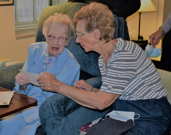 Sister Charlotte Walby (left) reminisces over a photo from her 101st birthday on Tuesday with her niece and goddaughter, Edie (Walby) Pollauf. Sister Charlotte, 106, is now the oldest IHM Sister and the longest-serving IHM Sister in the community’s history.
(Photo: PROVIDED BY IHM COMMUNICATIONS DEPARTMENT)