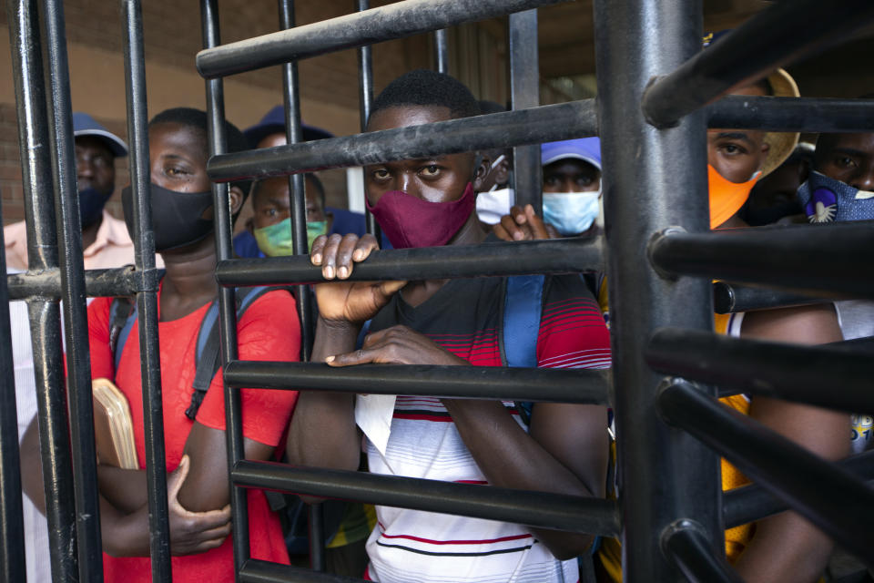 Tobacco farmers wait to enter the auction floors during an auction in Harare, Thursday, April 8, 2021. Zimbabwe’s tobacco is flourishing again. And so are the auctions where merchants are fetching premium prices for the “golden leaf” that is exported around the world. Many of the small-scale farmers complain they are being impoverished by middlemen merchants who are luring them into a debt trap. (AP Photo/Tsvangirayi Mukwazhi)