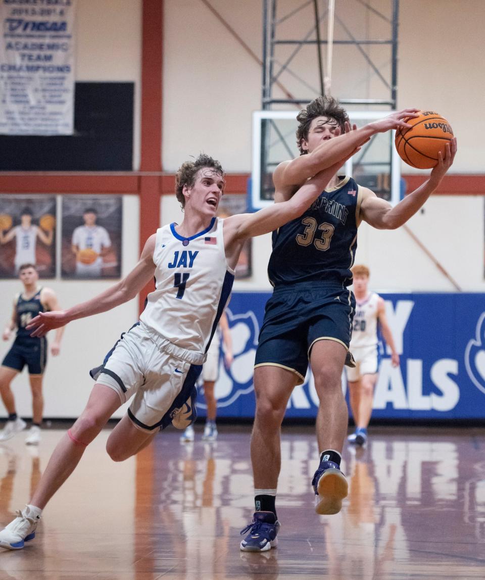 Ethan McDonald (4) fouls Reece Bloomberg (33) as he leaps for a high inbounds pass during the Gulf Breeze vs Jay boys basketball game at Jay High School on Tuesday, Jan. 18, 2022.