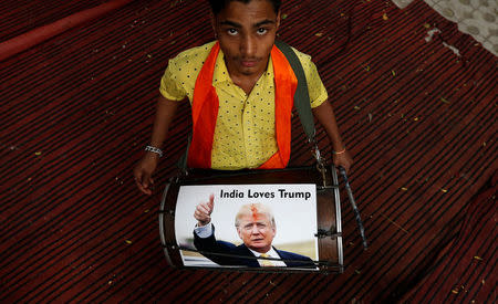 A member of Hindu Sena, a right-wing Hindu group, plays a drum with U.S. Republican presidential nominee Donald Trump’s picture on it as they symbolically celebrate his victory in the upcoming U.S. elections, in New Delhi, India, November 4, 2016. REUTERS/Adnan Abidi