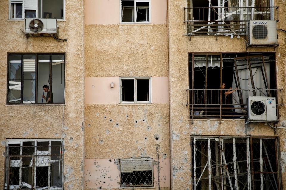 Israelis stand inside a building damaged by Hezbollah rocket fire in northern Israel on Tuesday (REUTERS)