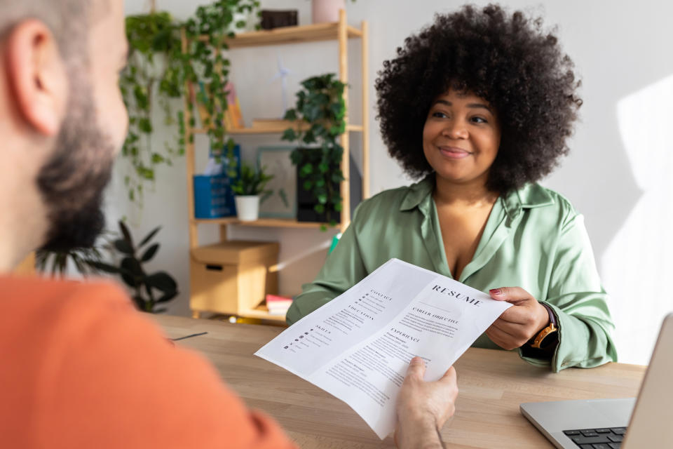 Person handing their résumé to a recruiter