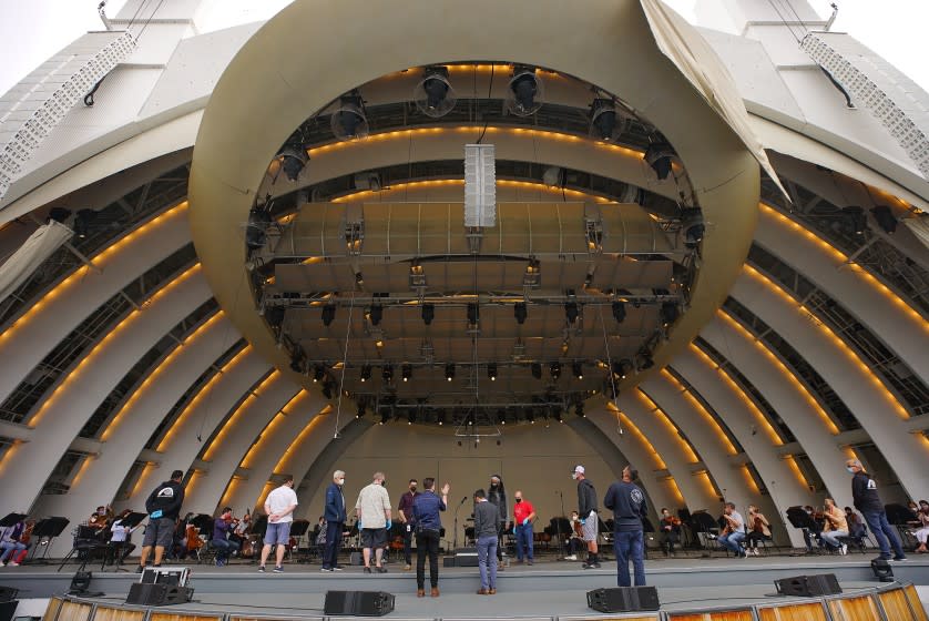 Workers onstage at the Hollywood Bowl prepare for morning rehearsal and the first public concert in 18 months.