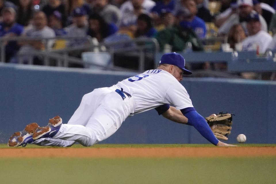 Los Angeles Dodgers second baseman Gavin Lux dives for a ball hit for single by Andres Gimenez during the fourth inning of a baseball game Friday, June 17, 2022, in Los Angeles. (AP Photo/Mark J. Terrill)