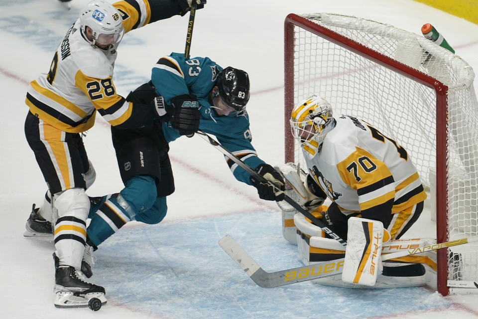 Pittsburgh Penguins defenseman Marcus Pettersson (28) and goaltender Louis Domingue, right, defend the goal against San Jose Sharks left wing Matt Nieto, middle, during the third period of an NHL hockey game in San Jose, Calif., Saturday, Jan. 15, 2022. (AP Photo/Jeff Chiu)