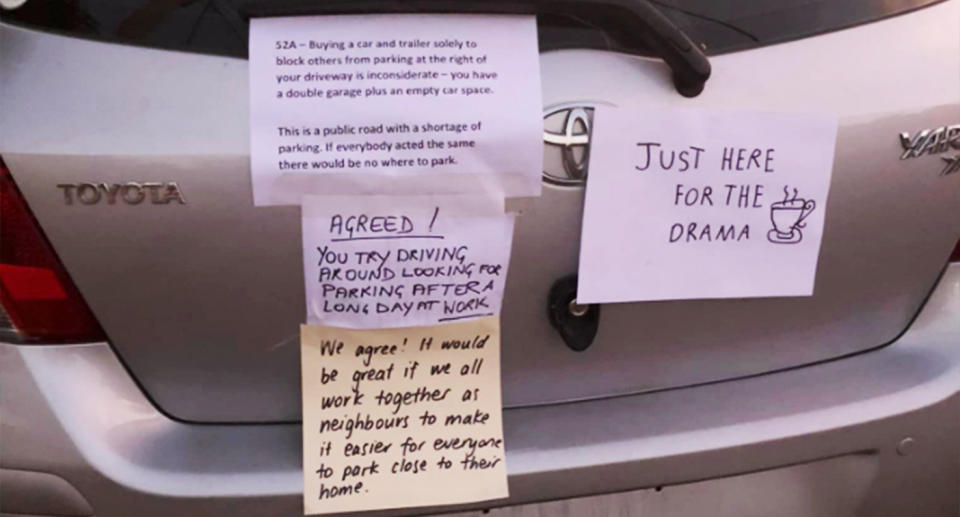 The notes plastered to the boot of the silver car. 