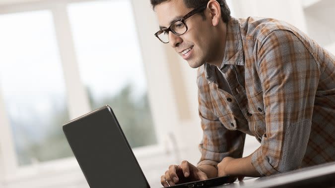 A man sitting using a laptop computer.
