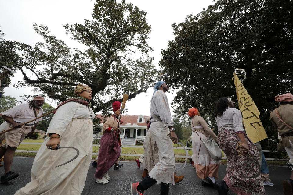 People participate in a performance artwork reenacting the largest slave rebellion in U.S. history in LaPlace, La., Friday, Nov. 8, 2019. The reenactment was conceived by Dread Scott, an artist who often tackles issues of racial oppression and injustice. Scott says that those who took part in the 1811 rebellion were "heroic" and that the rebellion is something that people should know about and be inspired by. (AP Photo/Gerald Herbert)