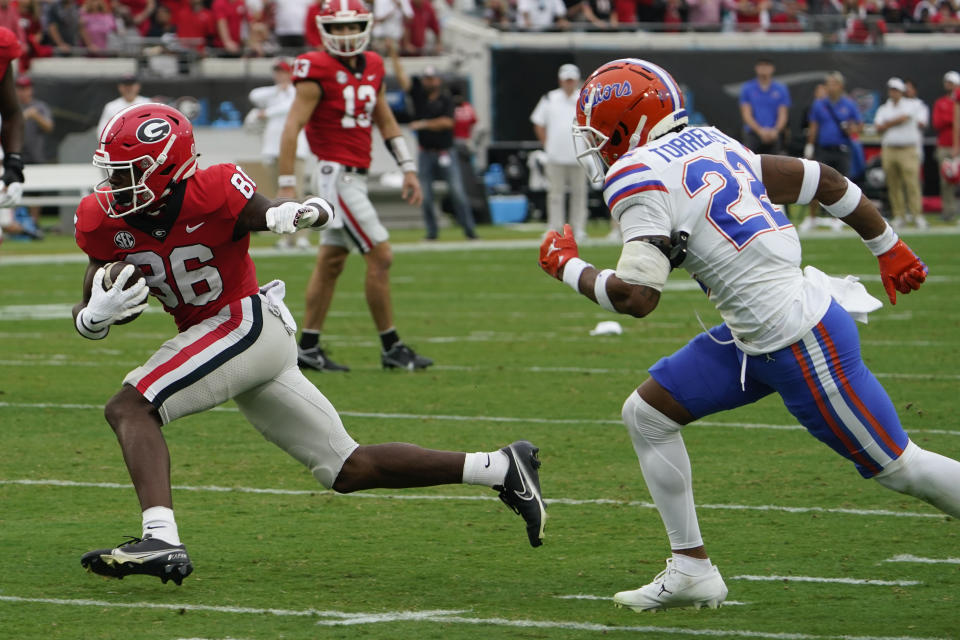 Georgia wide receiver Dillon Bell (86) runs past Florida cornerback Jaydon Hill (23) for yardage after a reception during the first half of an NCAA college football game Saturday, Oct. 29, 2022, in Jacksonville, Fla. (AP Photo/John Raoux)