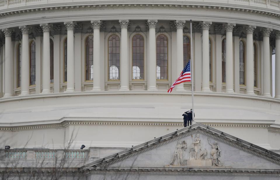 Capitol Hill Police salute as they lower the United States flag over the United States Capitol to half-staff on Jan. 8, 2021 after House Speaker Nancy Pelosi ordered the flags at the U.S. Capitol to be flown at half-staff following the death of U.S. Capitol Police Officer Officer Brian Sicknick who died after he was injured when President Donald Trump's supporters stormed the Capitol.