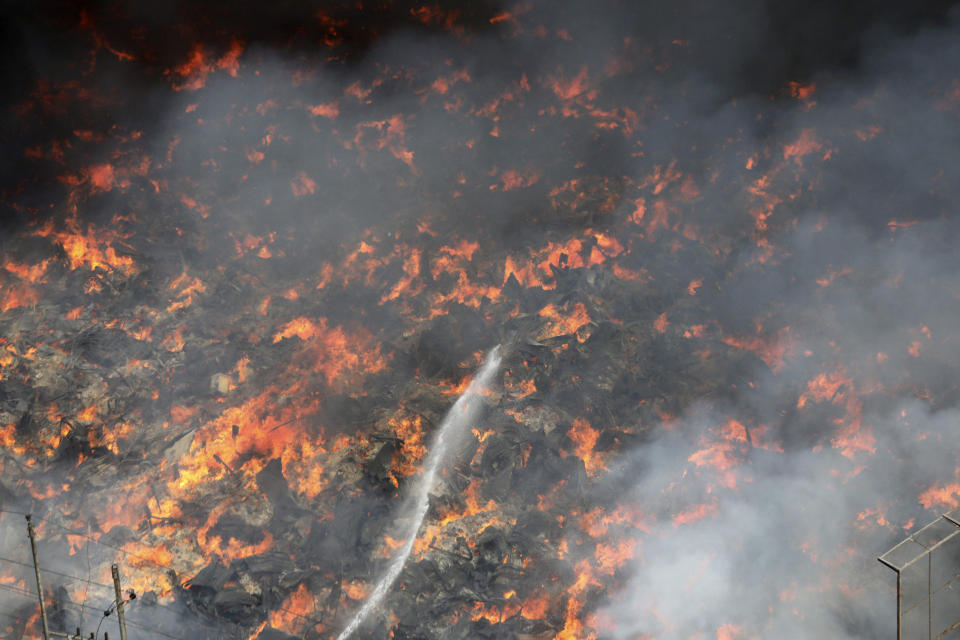 Firefighters work to contain a fire that broke out at a popular market for cheaper clothes in Bangladesh's capital Dhaka, Bangladesh, Tuesday, April, 4, 2023. The fire broke out at Bangabazar Market in Dhaka on Tuesday, but no casualties were reported immediately. (AP/Mahmud Hossain Opu)