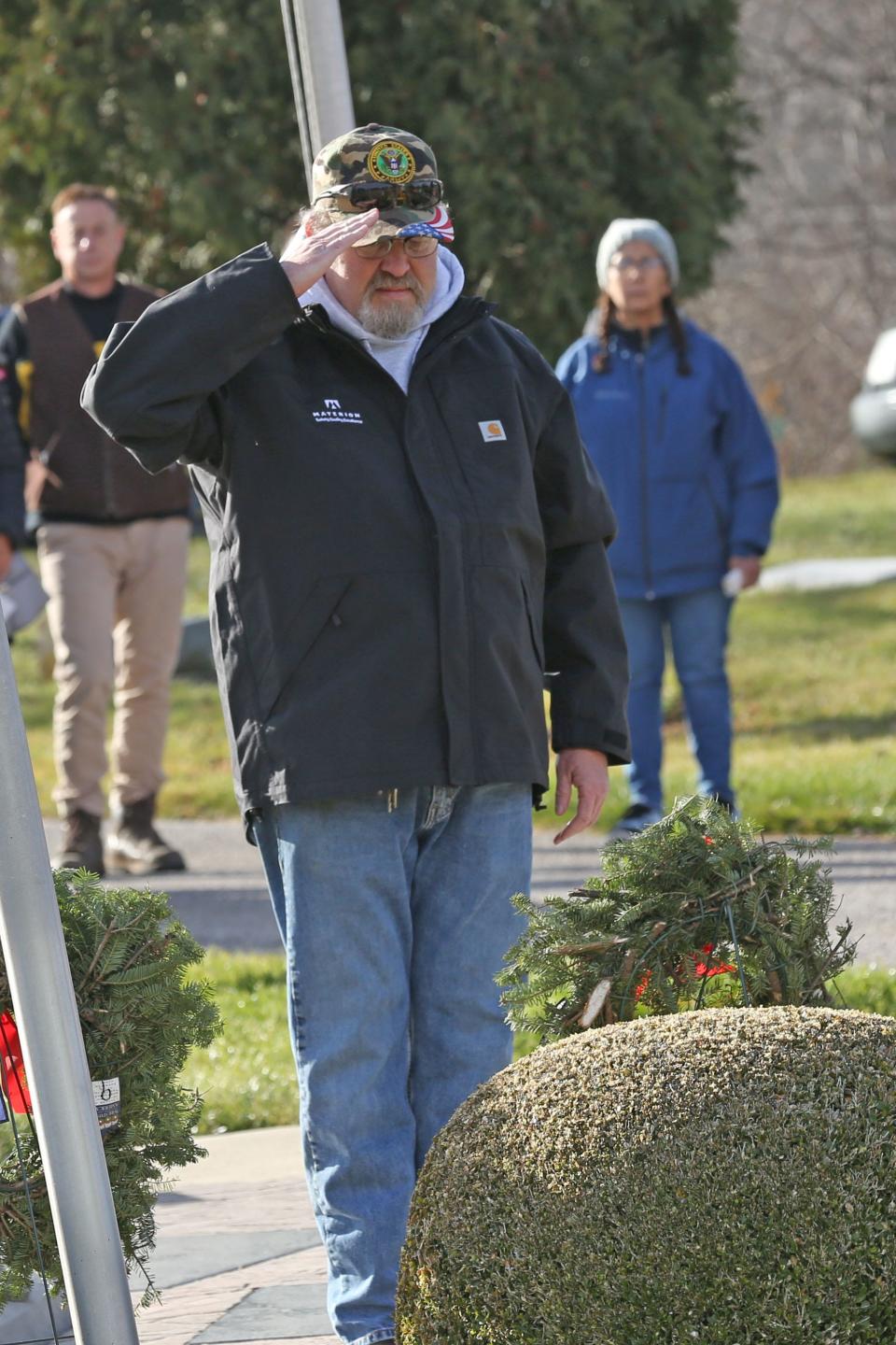 Sandusky County Army veteran Michael Wojtowicz salutes a wreath at Clay Township Cemetery, in Genoa. More than 2,000 wreaths were placed on veterans' graves across Ottawa County on Saturday by military servicemen and volunteers through the Wreaths Across America program.