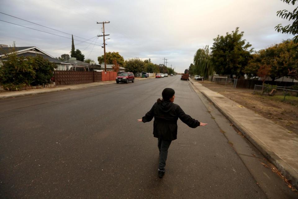 A woman walks down a mostly empty street.