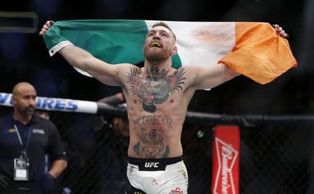 Nov 12, 2016; New York, NY, USA; Conor McGregor (blue gloves) celebrates after defeating Eddie Alvarez (red gloves) in their lightweight title bout during UFC 205 at Madison Square Garden. Mandatory Credit: Adam Hunger-USA TODAY Sports