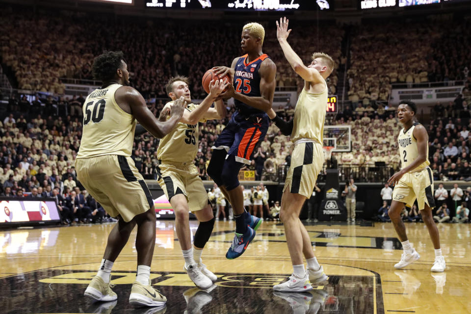 Virginia forward Mamadi Diakite (25) is stripped of the ball by Purdue guard Sasha Stefanovic (55), between Purdue's Trevion Williams (50) and Matt Haarms during the first half of an NCAA college basketball game in West Lafayette, Ind., Wednesday, Dec. 4, 2019. (AP Photo/Michael Conroy)