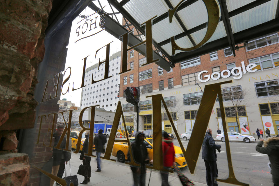 The Chelsea Market building's window sign and the sign for Google's New York City headquarters, are shown in this photo, Tuesday, March 20, 2018. Google Inc. has finalized the $2.4 billion purchase of New York City's Chelsea Market building, the former Nabisco factory, on Tuesday. (AP Photo/Richard Drew)