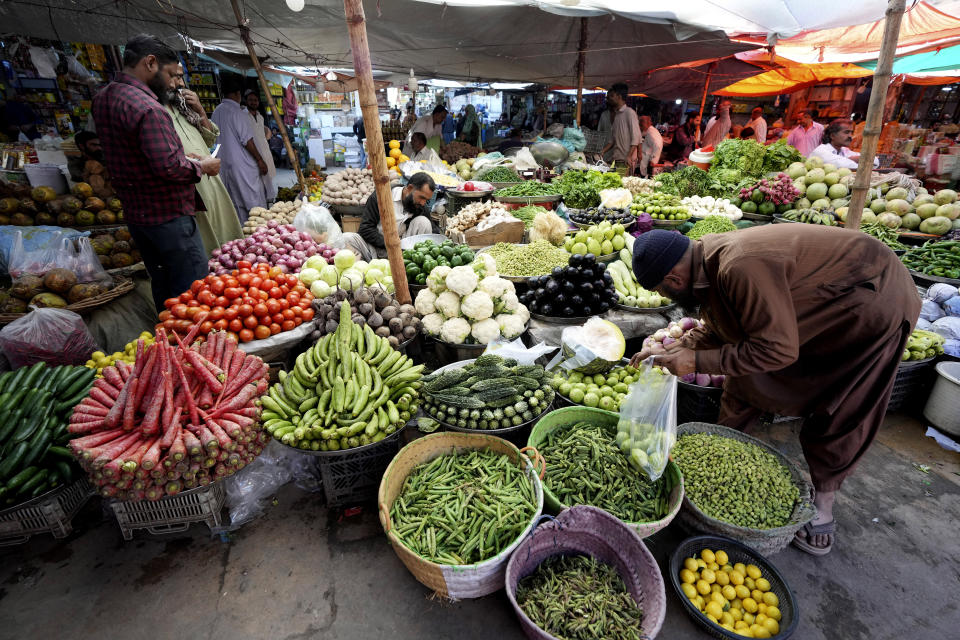 People visit a market to buy vegetables and other stuff, in Karachi, Pakistan, Tuesday, Feb. 14, 2023. Cash-strapped Pakistan nearly doubled natural gas taxes Tuesday in an effort to comply with a long-stalled financial bailout, raising concerns about the hardship that could be passed on to consumers in the impoverished south Asian country. Pakistan's move came as the country struggles with instability stemming from an economic crisis. (AP Photo/Fareed Khan)