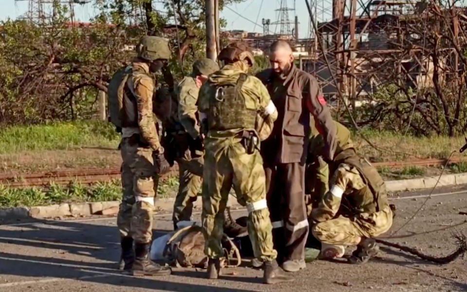 Russian soldiers search Ukrainian servicemen - RUSSIAN DEFENCE MINISTRY PRESS SERVICE HANDOUT/EPA-EFE/Shutterstock