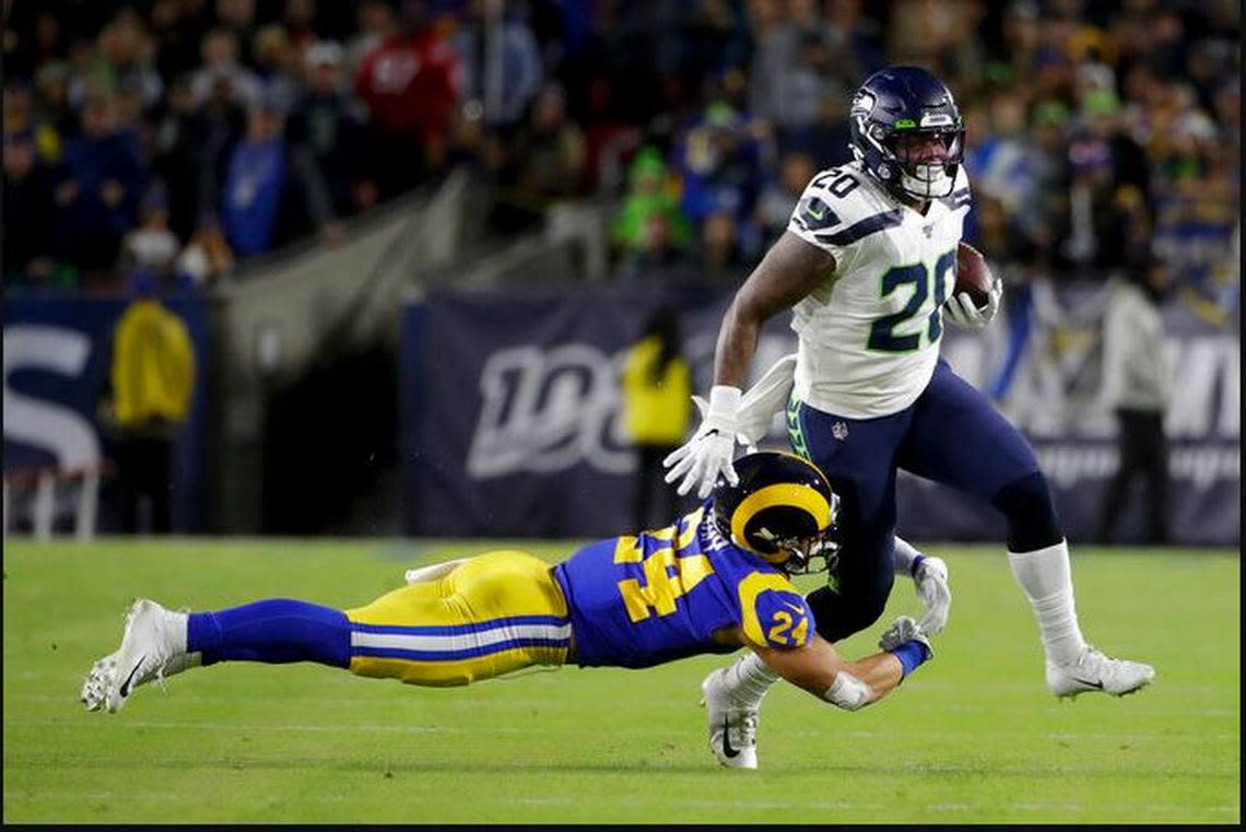 Running back Rashaad Penny injures his left knee after former University of Washington defense back Taylor Rapp (24) tackled him on this 16-yard catch and run early in the Seahawks’ game against the Rams Sunday night at the Los Angeles Memorial Coliseum