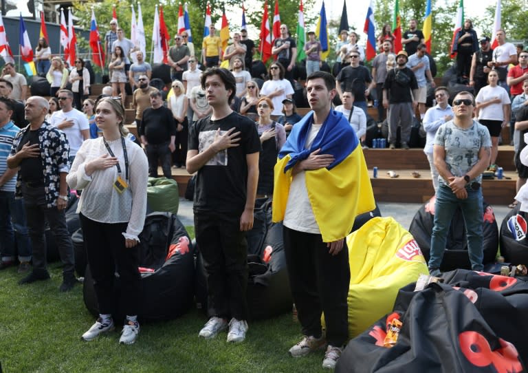 Des fans ukrainiens pendant leur hymne national avant le match de l'Euro-2024 contre la Slovaquie, dans une fan zone à Kiev en Ukraine. (Anatolii STEPANOV)