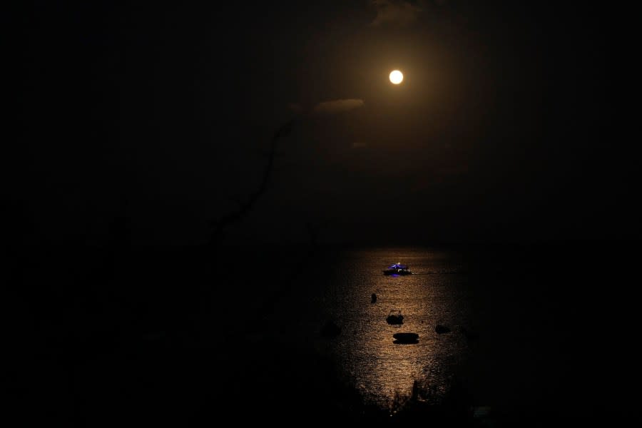 The supermoon rises over the Mediterranean sea as a boat passes at Konnos bay near Ayia Napa and Protaras on the eastern part of the island of Cyprus, on Wednesday, Aug. 30, 2023. The cosmic curtain rose Wednesday night with the second full moon of the month, the reason it is considered blue. It’s dubbed a supermoon because it’s closer to Earth than usual, appearing especially big and bright. (AP Photo/Petros Karadjias)