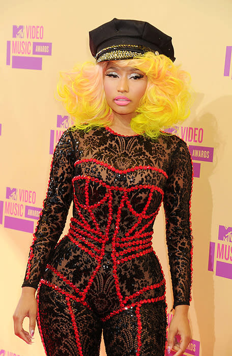 2012 – Nicki Minaj mélange les styles, entre pin-up, policière bling-bling et inspirations baroques… Dommage, son look ne met pas en valeur sa combinaison en dentelle qui est très originale grâce aux strass rouges dessinant une autre tenue.