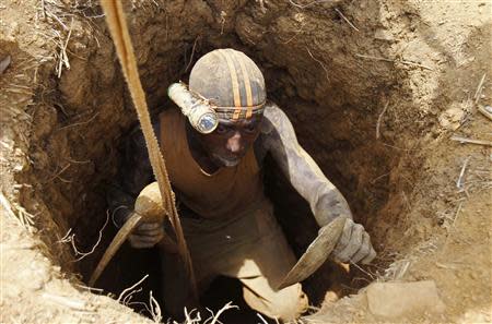 A prospector goes down a hole as he pans for gold at a new gold mine found in a cocoa farm near the town of Bouafle in western Ivory Coast March 20, 2014. REUTERS/Luc Gnago