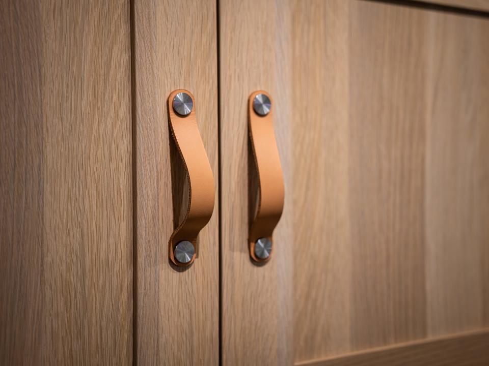 Light brown leather cabinet pulls on light wood