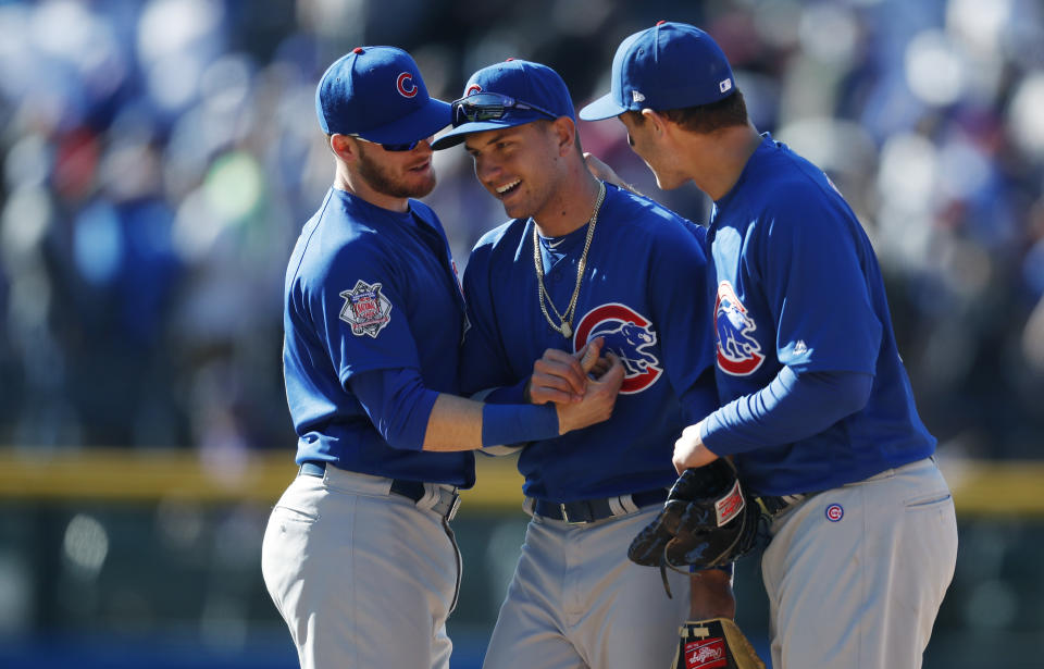 Chicago Cubs center fielder Albert Almora Jr., center, is congratulated by third baseman Ian Happ, left, and first baseman Anthony Rizzo after the Cubs stopped the Colorado Rockies in the ninth inning of a baseball game Sunday, April 22, 2018, in Denver. The Cubs won 9-7. (AP Photo/David Zalubowski)