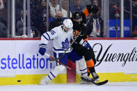 Toronto Maple Leafs' Mark Giordano, left, and Philadelphia Flyers' Zack MacEwen work along the boards during the second period of an NHL hockey game Saturday, April 2, 2022, in Philadelphia. (AP Photo/Derik Hamilton)