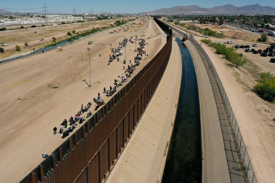 An aerial image shows migrants waiting along the border wall to surrender to US Customs and Border Protection (CBP) Border Patrol agents for immigration and asylum claim processing after crossing the Rio Grande river into the United Staes on the US-Mexico border in El Paso, Texas, on May 10, 2023 (AFP via Getty Images)