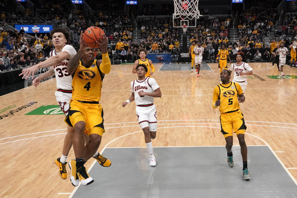 Missouri's DeAndre Gholston (4) heads to the basket as Illinois' Coleman Hawkins (33) defends during the first half of an NCAA college basketball game Thursday, Dec. 22, 2022, in St. Louis. (AP Photo/Jeff Roberson)