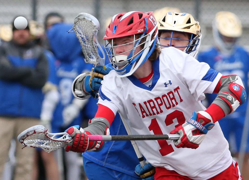 Fairport's Corey Roeser gathers in the ball as he wins the face off against Schroeder's Ross Champlin.