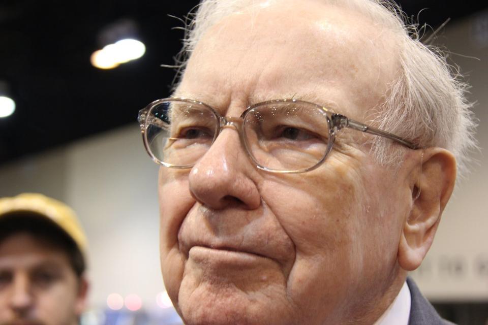 Warren Buffett surrounded by people at the annual Berkshire Hathaway shareholders meeting.