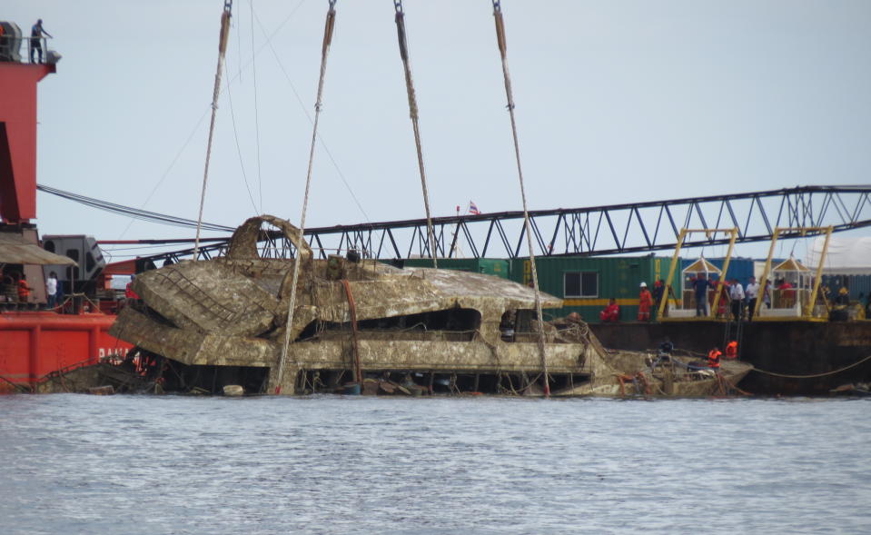 A crane boat raises the tour boat named the Pheonix from the sea floor, Saturday, Nov. 17, 2018, in Phuket, Thailand, after sinking over four months ago in rough weather killing 47 tourists. The tour boat was one of two boats that sank off the popular tourist island in stormy weather on July 5, 2018. (AP Photo)