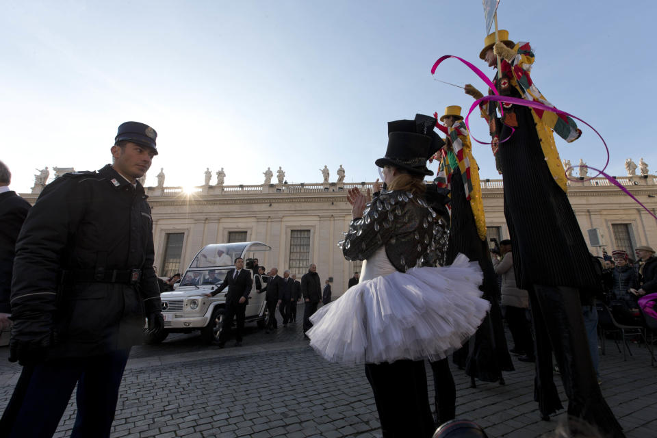 Members of the Golden Circus welcome Pope Francis as he arrives for his weekly general audience in St. Peter's Square at the Vatican, Wednesday, Jan. 8, 2014. (AP Photo/Alessandra Tarantino)