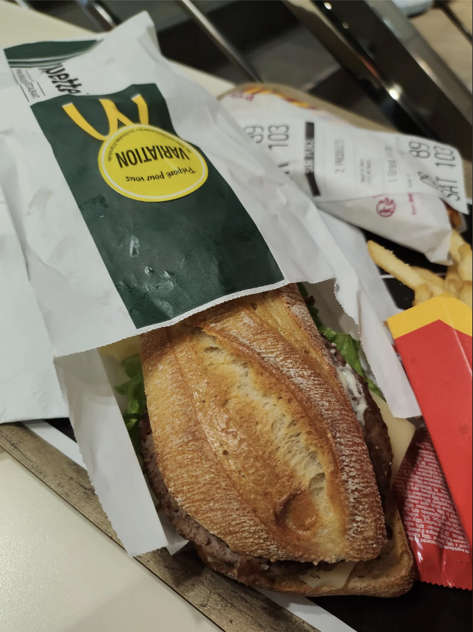 McDonald's bag with logo, steak sandwich in a tray, and fries on the side